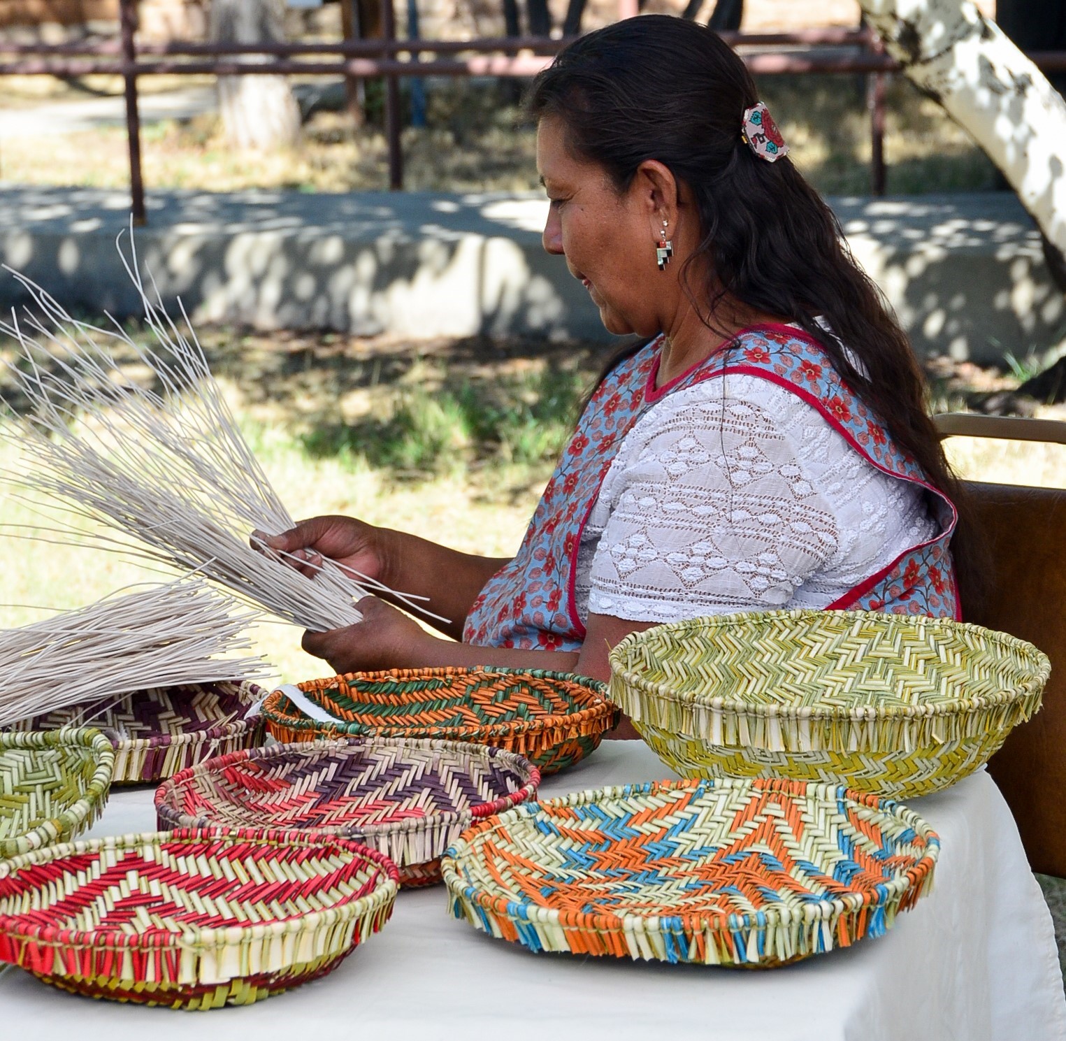 An indigenous woman demonstrating basket weaving.