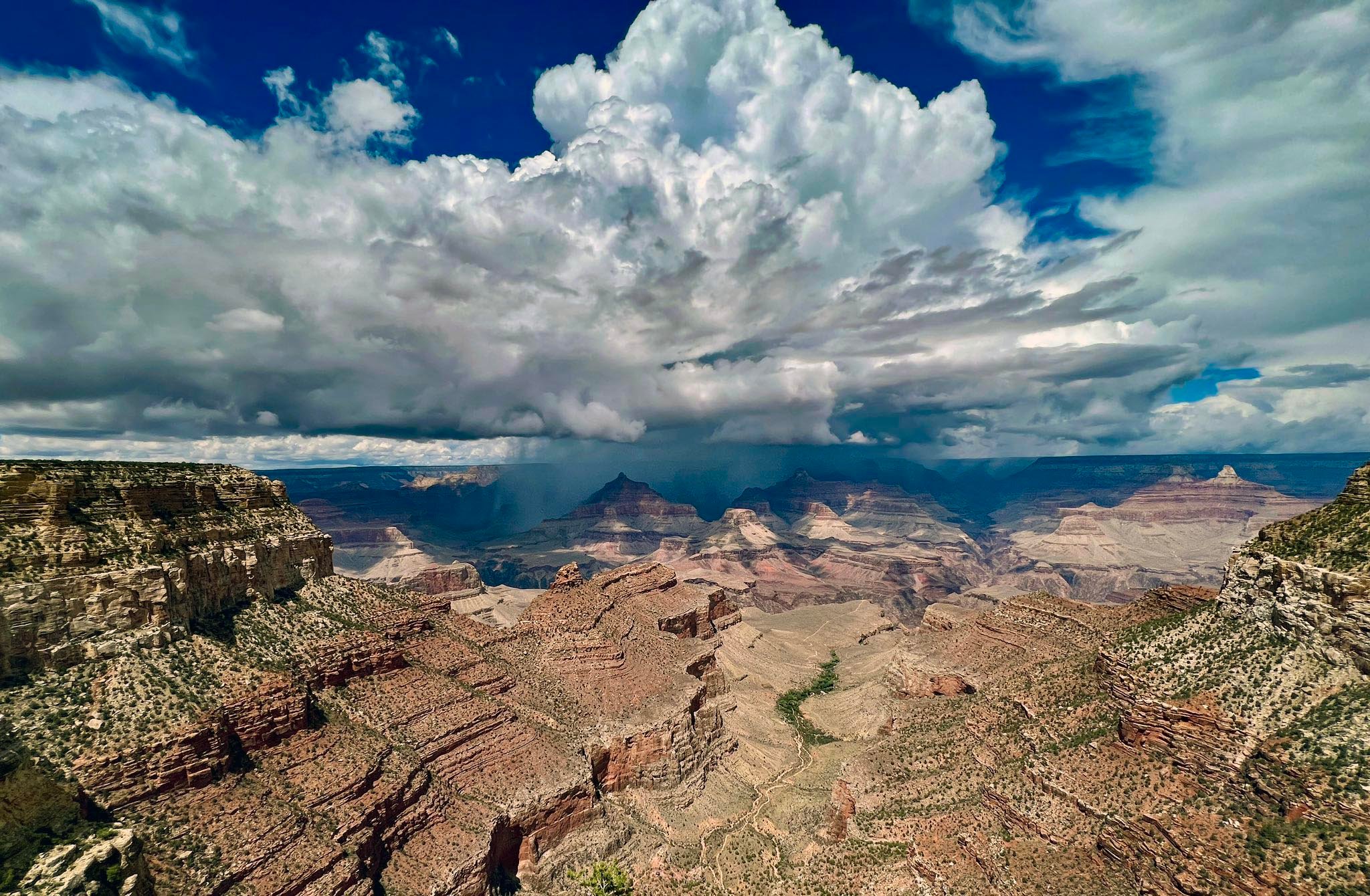 Billowy white clouds over a canyon landscape