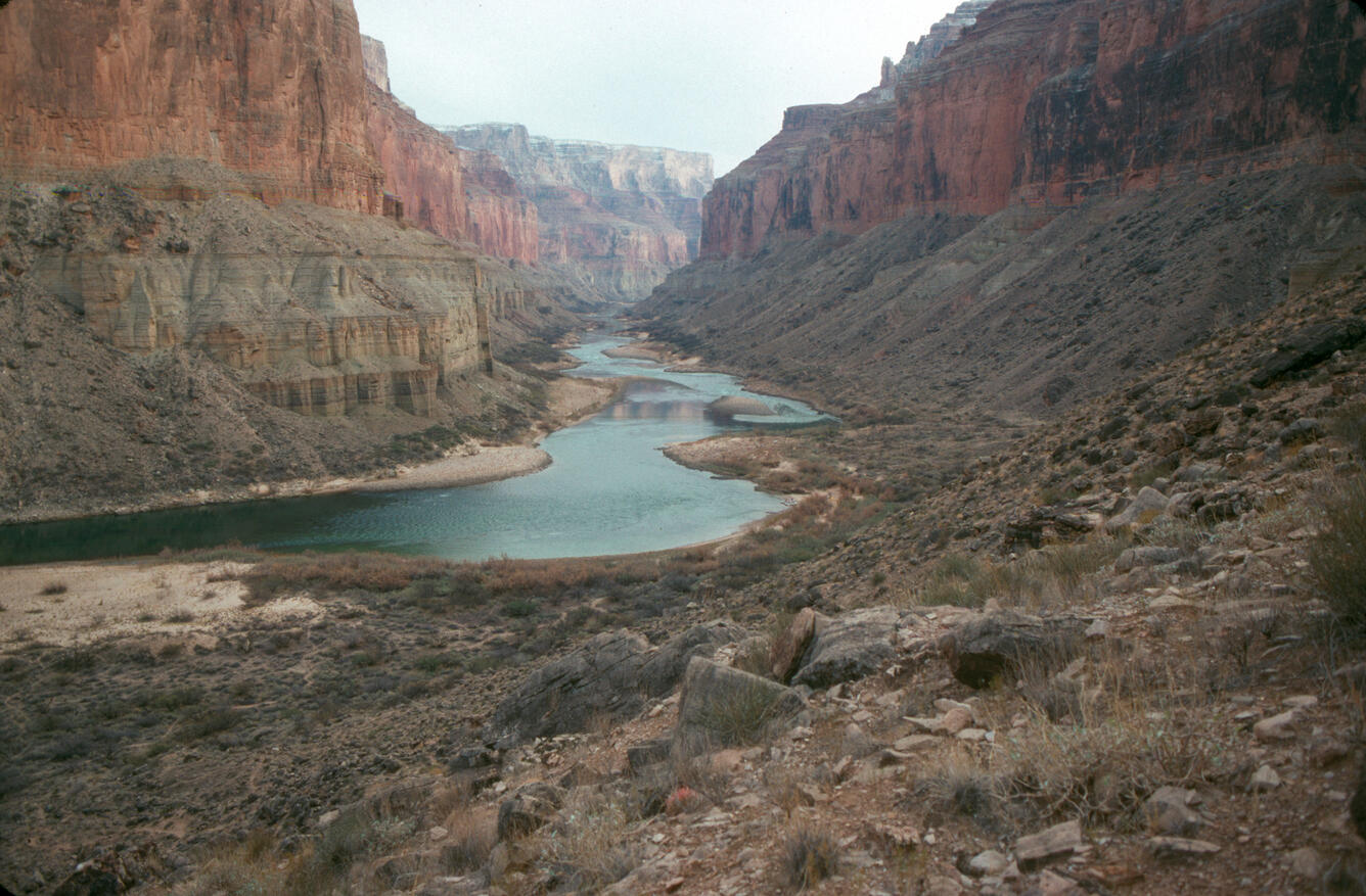 The Colorado River with steep cliffs inside Grand Canyon