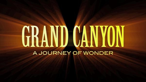 Against a black background, glowing yellow letters spell: Grand Canyon A Journey of Wonder.