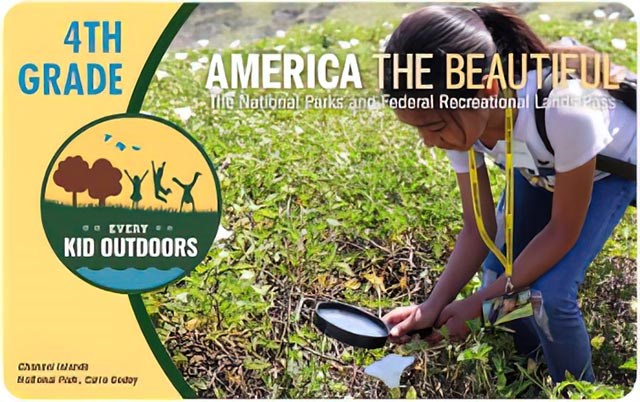 4th Grade, Every Kid Outdoors 2021-2022 pass graphic shows a girl in a green meadow examining something through a large round magnifying glass.