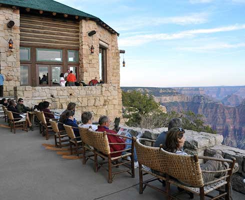 Visitors sitting on the veranda of the North Rim Lodge looking out at Grand Canyon