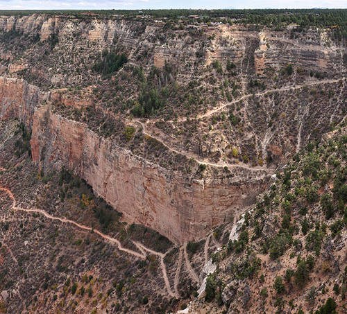 View of a trail going down steep cliff terrain.