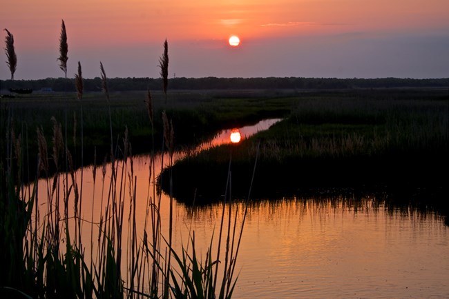 The setting sun reflects in the river waters.