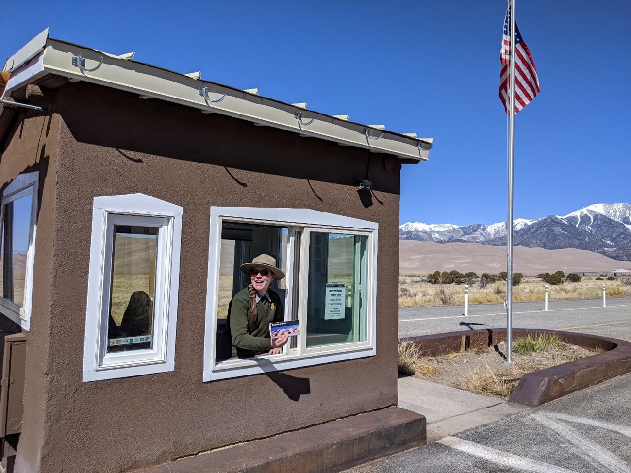 Park Ranger Melinda McFarland greets visitors from inside the park's entrance station.