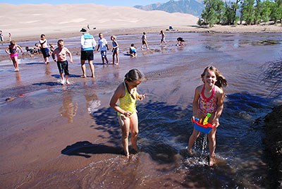 Children and families playing in Medano Creek at low flow