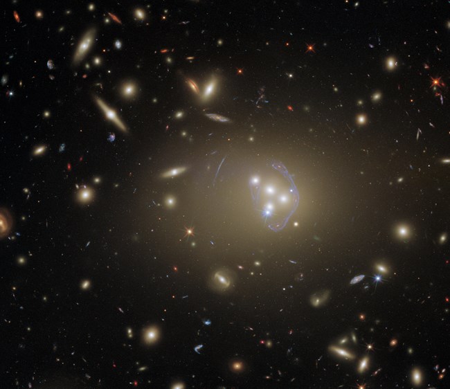 Glowing galaxies are sprinkled across dark space