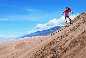 Girl Sandboarding on First Ridge of Dunes