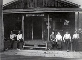 Men standing near the front porch of the Elkmont Post Office and store.