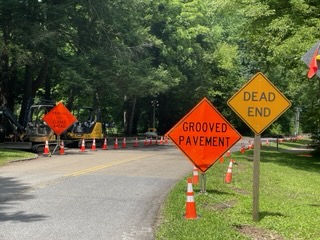 Orange road construction signs and cones inform visitors of road work