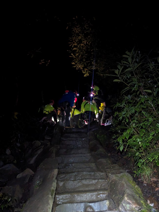 A rescue crew on a trail at night.