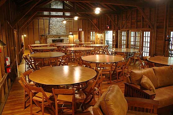 The meeting room is furnished with round tables and folding chairs.