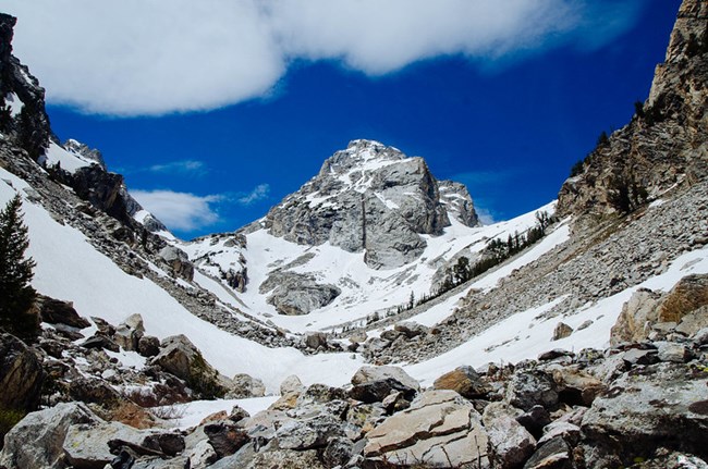 Rock and snow filled canyon with bright blue sky
