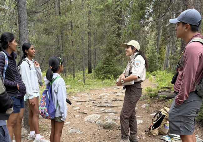 A person talking to other people in a forest
