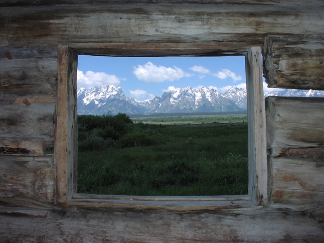 Looking through a log and timber window at the Teton Range