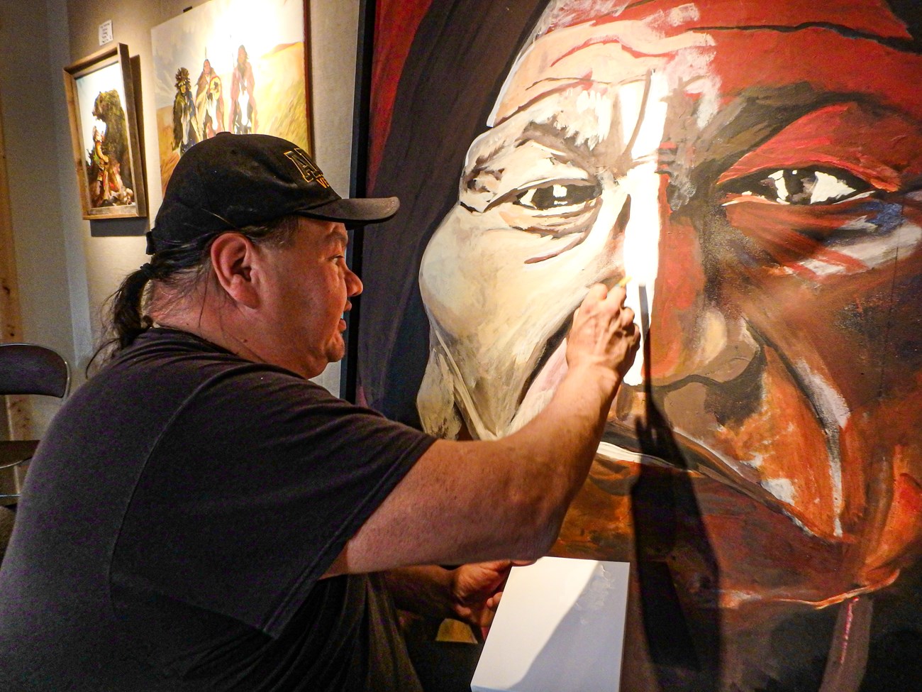a Native artist paints a large face