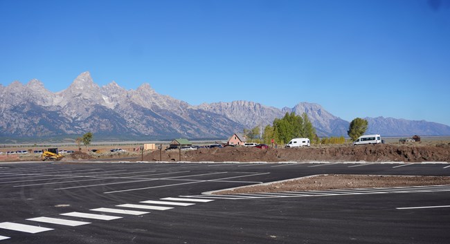 View of newly paved parking lot at Mormon Row with historic structures in background