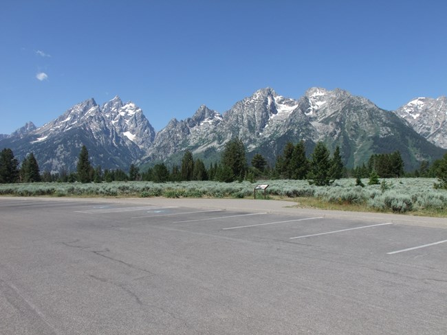 Parking lot with mountains and sagebrush in background.