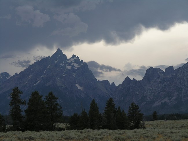Storm clouds overhead with mountains in background