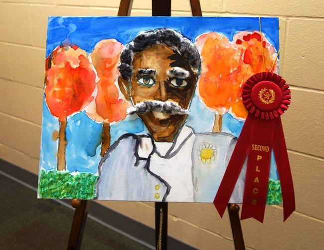 Image is a colorful painting of George Washington Carver by a student in the annual Art and Essay contest.