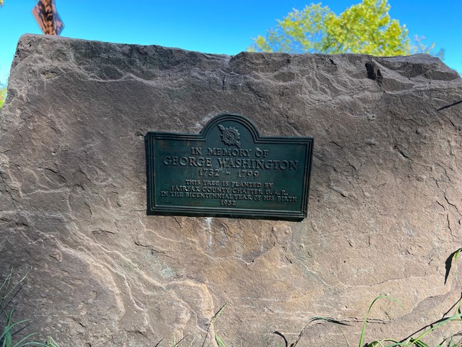 A plaque attached to a stone.