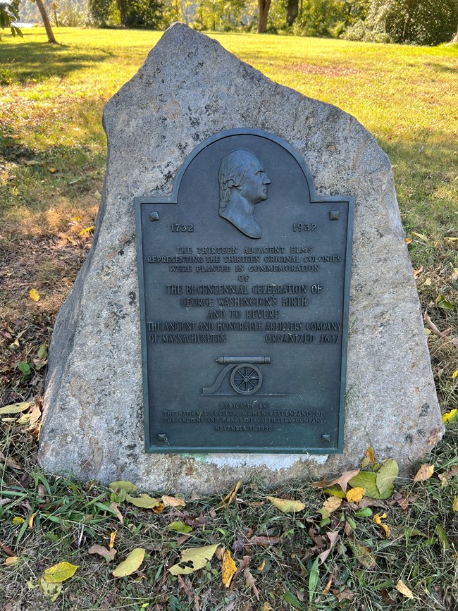 A plaque attached to a stone.