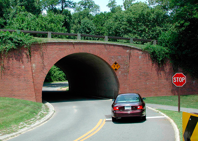 Car at stop sign beneath low bridge at Fort Hunt