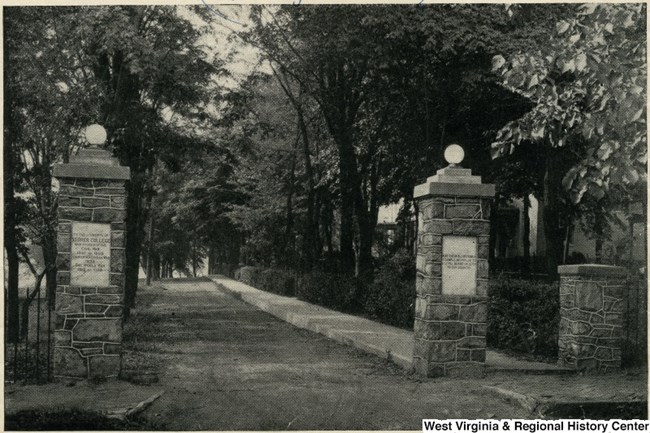 black and white photo of stone pillars, gateway and path