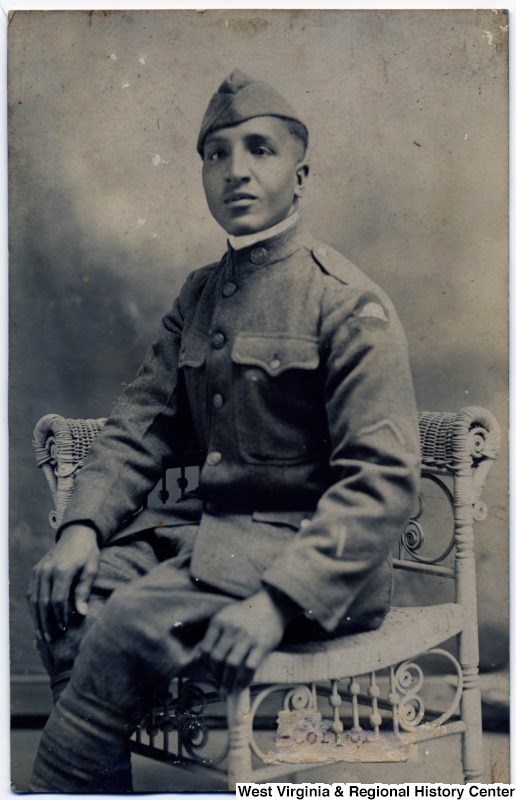 African American man seated, posing in a photography studio, wearing his WWI military uniform