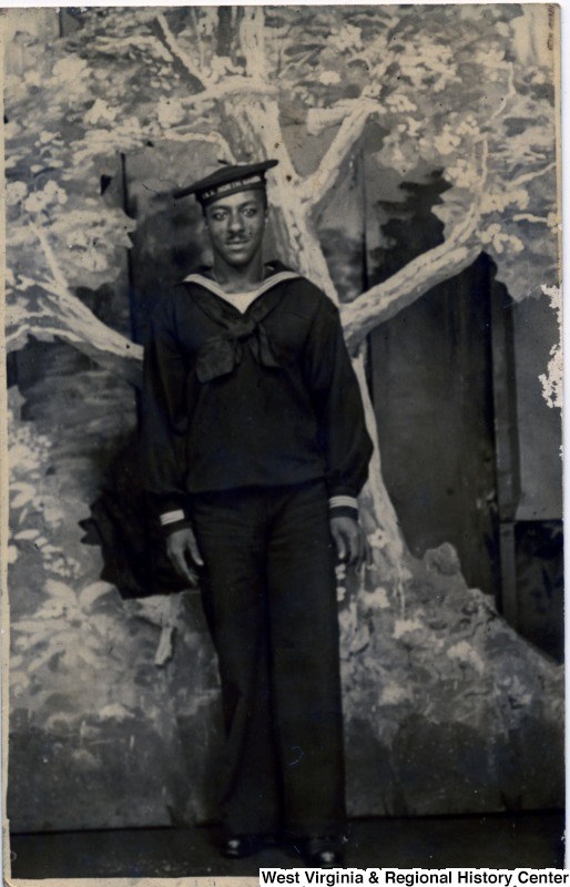African American man posing in a photography studio, wearing his World War I navy uniform