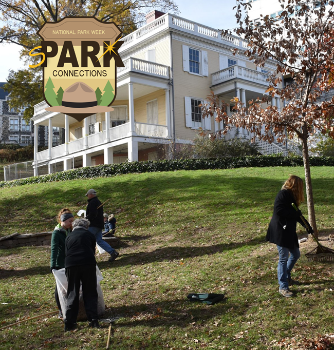 A group of people raking leaves in front of The Grange.