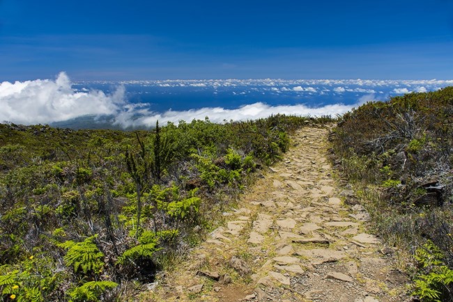 trail comprised of rocks looks out toward clouds