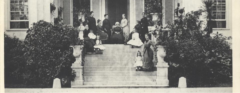 A black and white photograph of women on the front porch of the Hampton mansion.