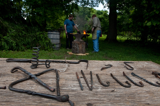 Image of a blacksmith at work at Hampton with some of his tools on display.