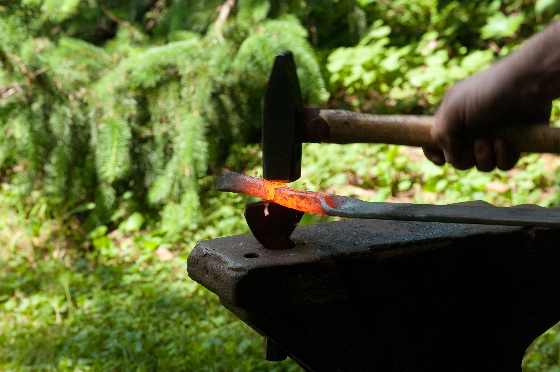 A hammer striking hot iron on an anvil.