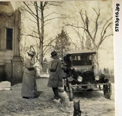 black and white photo of man and woman and automobile