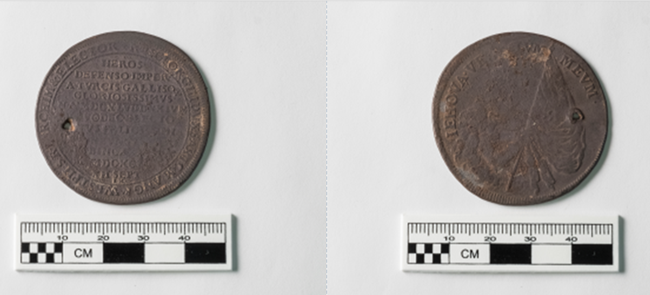 Both sides of a 17th century pierced coin.