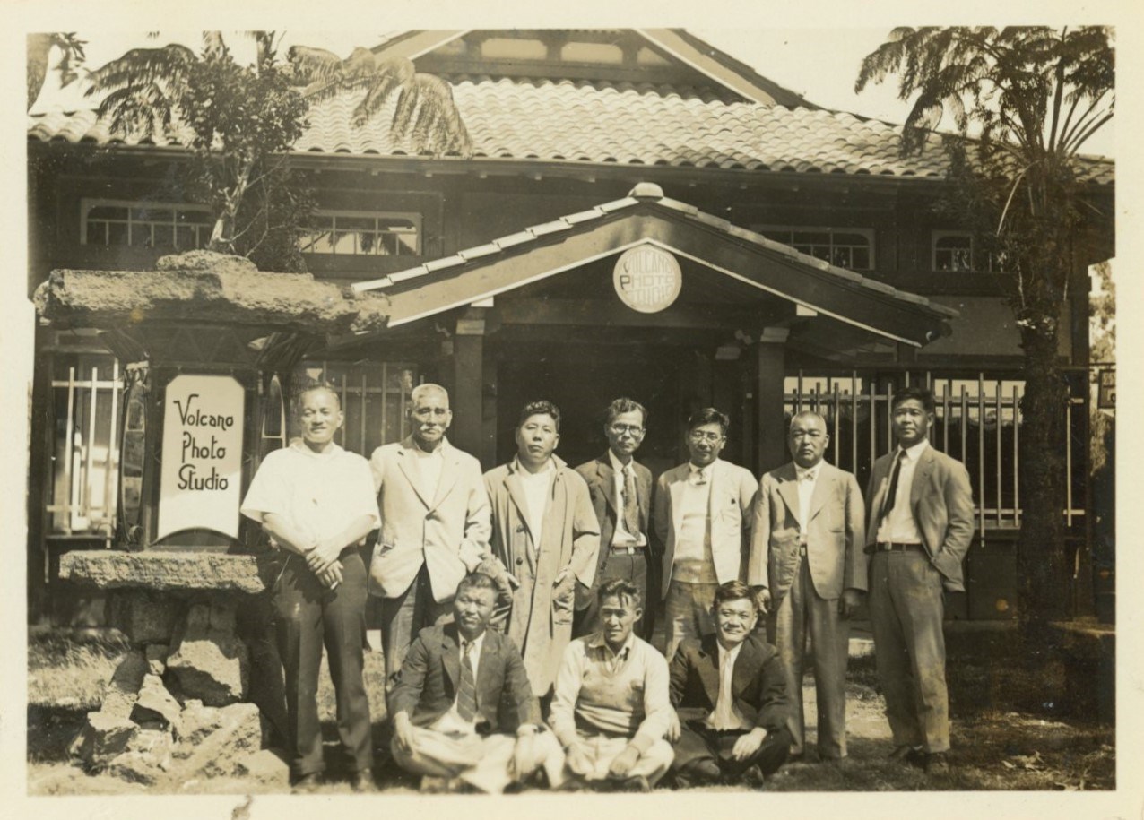 A black and white group portrait. People standing in front of Volcano Photo Studio.