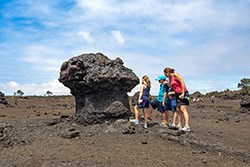 Hikers next to a lava formation
