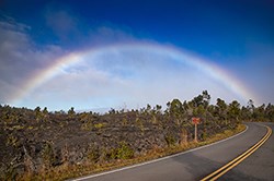 Rainbow on the side of a road in a lava landscape