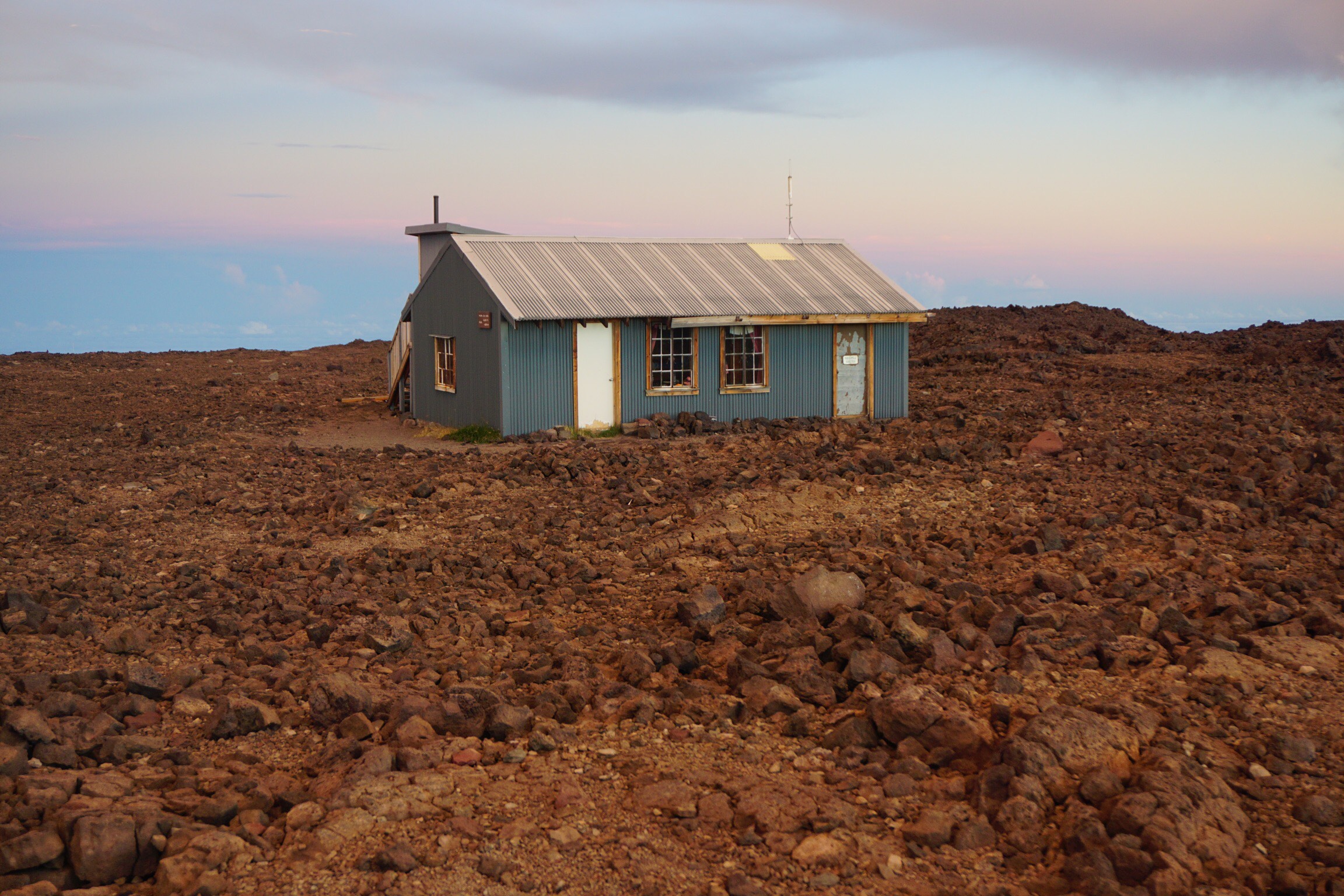A cabin near the edge of a volcanic crater.