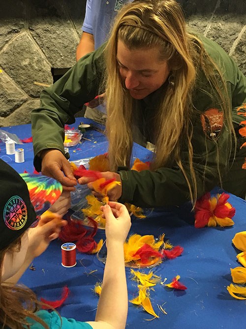 Park ranger demonstrates feather kāhili making, offered at this month's Kahuku ‘Ohana Day