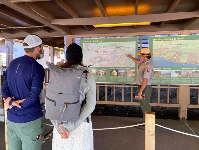 Ranger showing visitors directions on a park map.