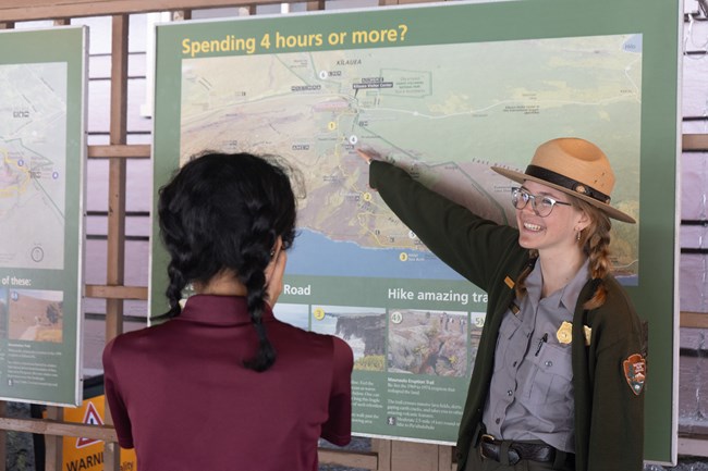 Ranger showing visitors directions on a park map.