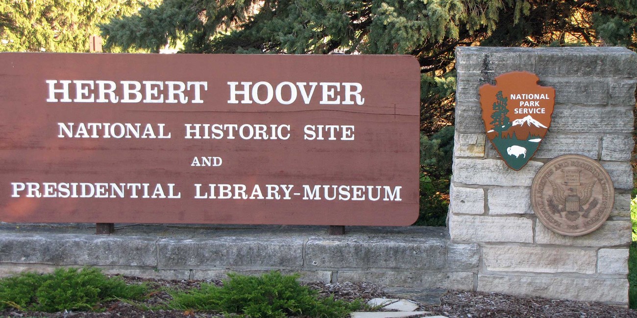 A stone and wood sign marks the entrance to Herbert Hoover park and museum.