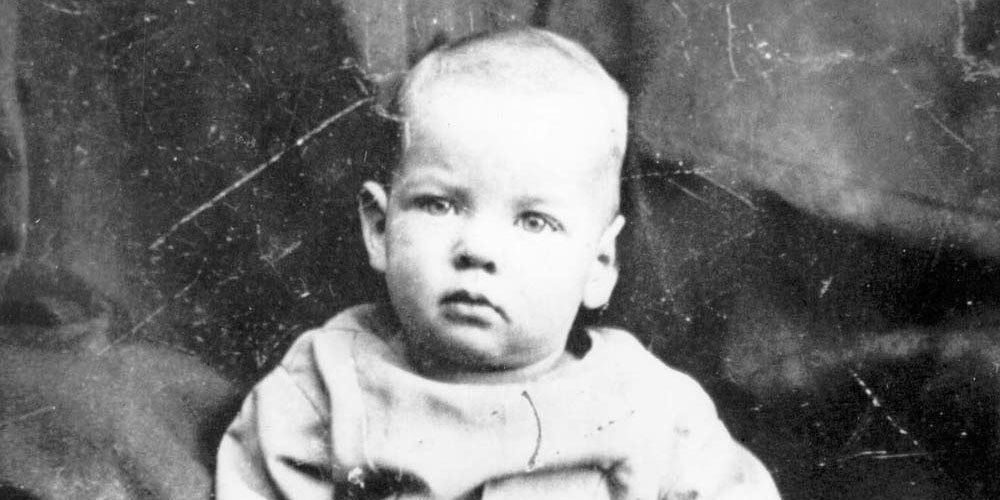 A one year old sits for a portrait photo in 1875.