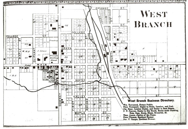 A black and white map drawing depicts a small town with a railroad.