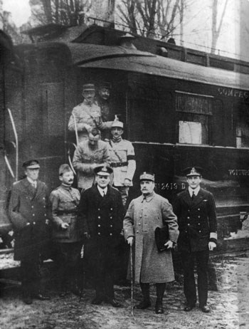 Nine men in uniforms stand near the end of a train car