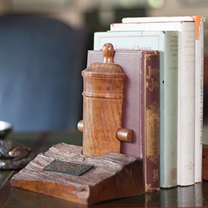 A wood bookend carved in the shape of a cannon.