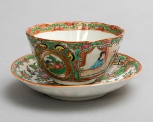 A teabowl and sacuer decorated with floral motifs, birds, butterflies and Chinese figures.